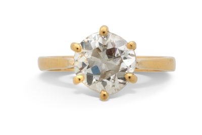 un gros plan sur une bague de fiançailles en or sertie d'un diamant blanc