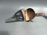 a small metal scoop with a leather handle on a table