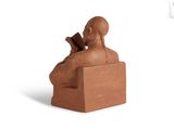 statue of a man reading a book in a chair