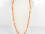 an orange beaded necklace on a mannequin neck