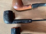 a lot of different types of smoking pipes on the table