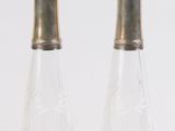 deux salières et poivrières en verre transparent posées sur une surface blanche