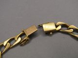 un gros plan sur un bracelet en or orné d'un cadenas
