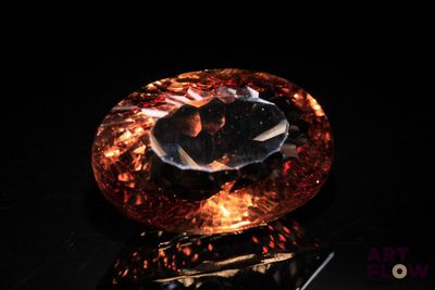 an orange and black diamond sitting on top of a black surface