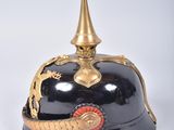 an old helmet with a dragon on it sitting on a white surface