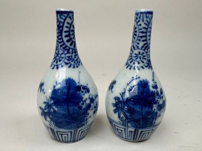 une paire de vases bleus et blancs posés sur une table blanche
