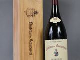 the bottle of wine is sitting next to the wooden box