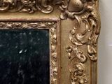 a gold frame with a mirror in it on the wall