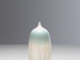 a small white and blue vase sitting on a table