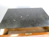 un plateau en marbre noir posé sur un coffret en bois