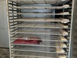 a metal rack with several trays of food on it