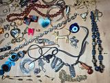 many different types of necklaces and bracelets on a table