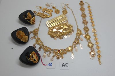 Plusieurs bijoux en or sont exposés sur un fond blanc
