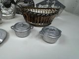 many silver dishes and pans sitting on a table