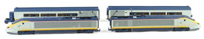 two model trains sitting side by side on a white surface