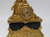 a gold clock sitting on top of a black table