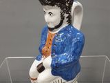 une figurine d'un homme assis sur une chaise