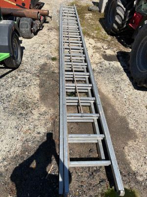 une échelle posée par terre à côté d'un tracteur