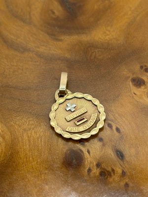 an image of a gold pendant with a cross on it