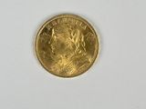 gros plan d'une pièce d'or sur une surface blanche
