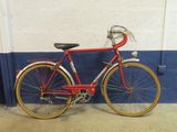 a red bicycle parked against a wall in a garage