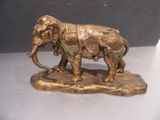 bronze statue of an elephant with a saddle on its back