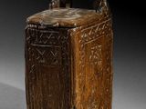 une vieille boîte en bois munie d'une poignée, sur un fond gris