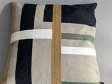 a close up of a pillow on a white surface with a tag