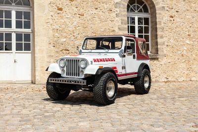 a white jeep parked in front of a stone building
