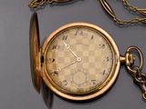 a gold pocket watch with a chain around it