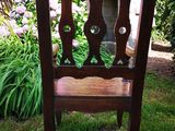 a wooden chair that is sitting in the grass