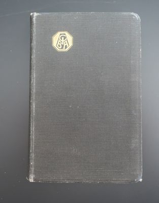 un vieux livre posé sur une table à côté d'une table noire