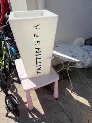 a white container sitting on top of a pink chair