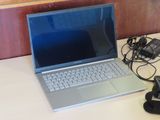 a laptop computer sitting on a desk next to a phone