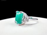 an image of a ring with a green stone on it