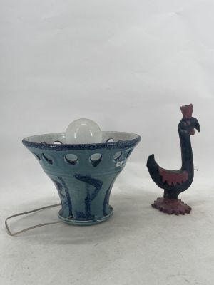 a blue vase with a bird figurine next to it
