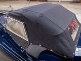 a blue car with a black top parked in a parking lot