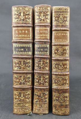 three old books sitting on top of each other on a table