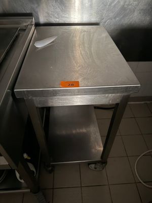 a stainless steel table in the middle of a kitchen