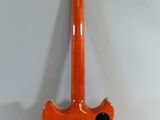 an orange electric guitar sitting on top of a white wall
