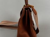 brown leather handbag on a white background with a strap