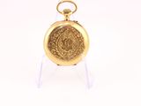gold plated pocket watch on clear acrylic stand on white background