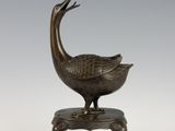 an image of a bronze statue of a bird on a stool