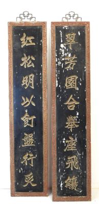 two plaques with asian writing on them on a wall