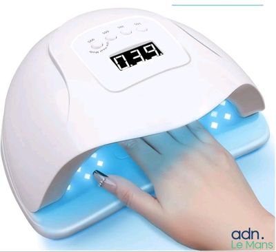 Le sèche-ongles est utilisé sur les ongles d'une femme.