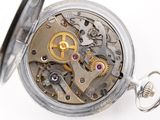 a close up of a pocket watch on a white surface