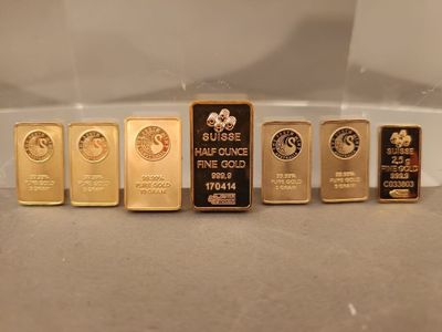 cinq lingots d'or sont alignés sur une table