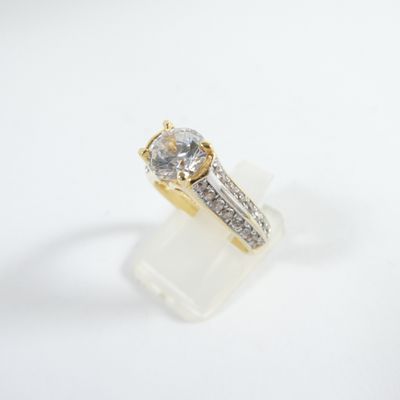 an image of a gold and diamond ring on a white surface