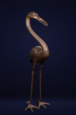 a bronze statue of a bird on a blue background