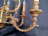 a gold colored chandelier with two candles on it